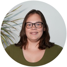 Das Bild zeigt eine Frau die neben einer Blume steht.