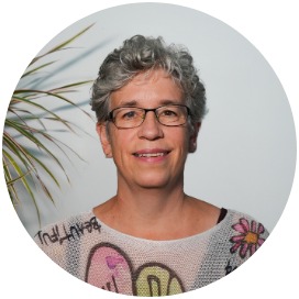 Das Bild zeigt eine Frau die neben einer Blume steht.